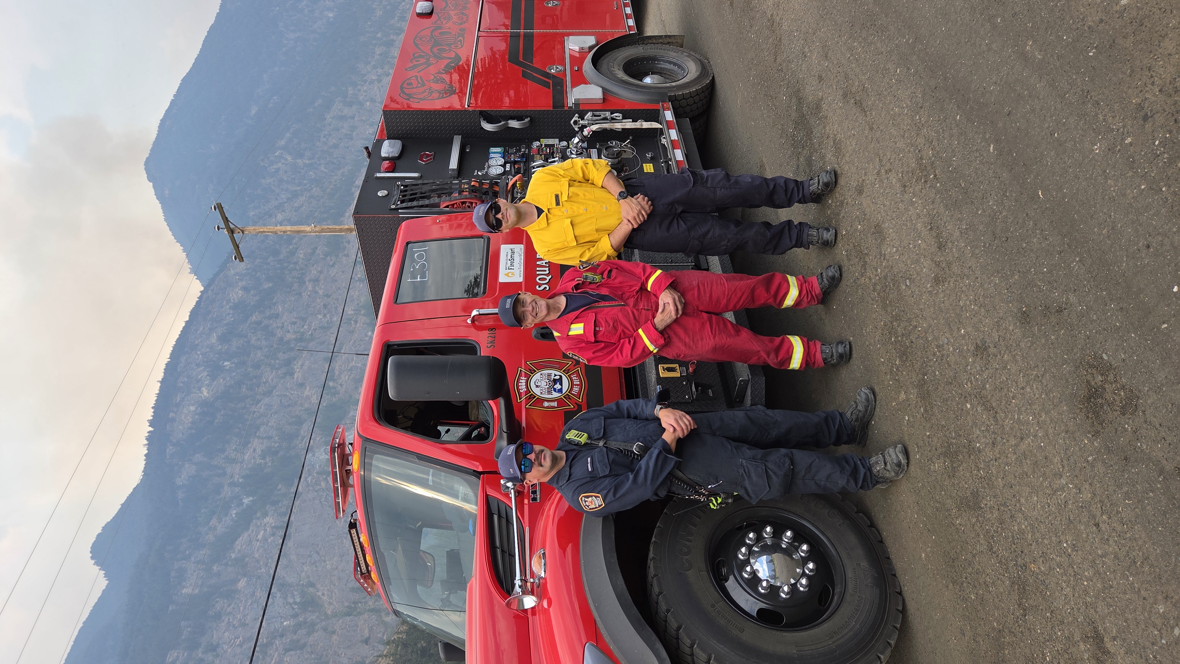 District of Sooke responders stand together for a photo beside vehicles and equipment deployed to support wildfire response efforts in British Columbia.